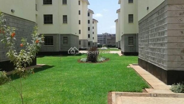A courtyard with a central garden, surrounded by multi-story buildings with uniform windows and a clean, modern design. - Stay.Plus Kahawa Sukari Apartment (Ruiru)