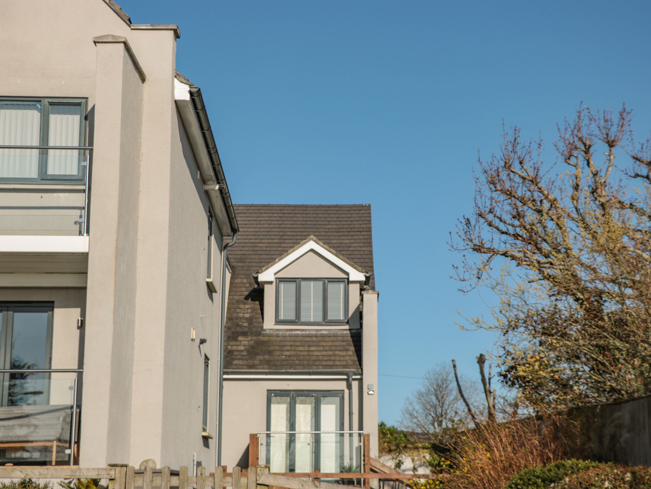 A modern two-story building with a flat roof and a small dormer window.