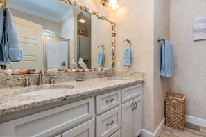 A bathroom with two sinks, a large mirror, and a decorative wall. - Awake On The Gulf - Gulf Front! Gaze Up At The Stars From Your Large Deck While Listening To The Waves Crash. 4 Bedroom Home by RedAwning (Dauphin Island)