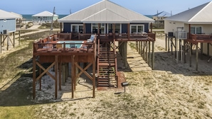 Ein Strandgrundstück mit Schwimmbad, Holzterrasse und mehreren Ebenen.