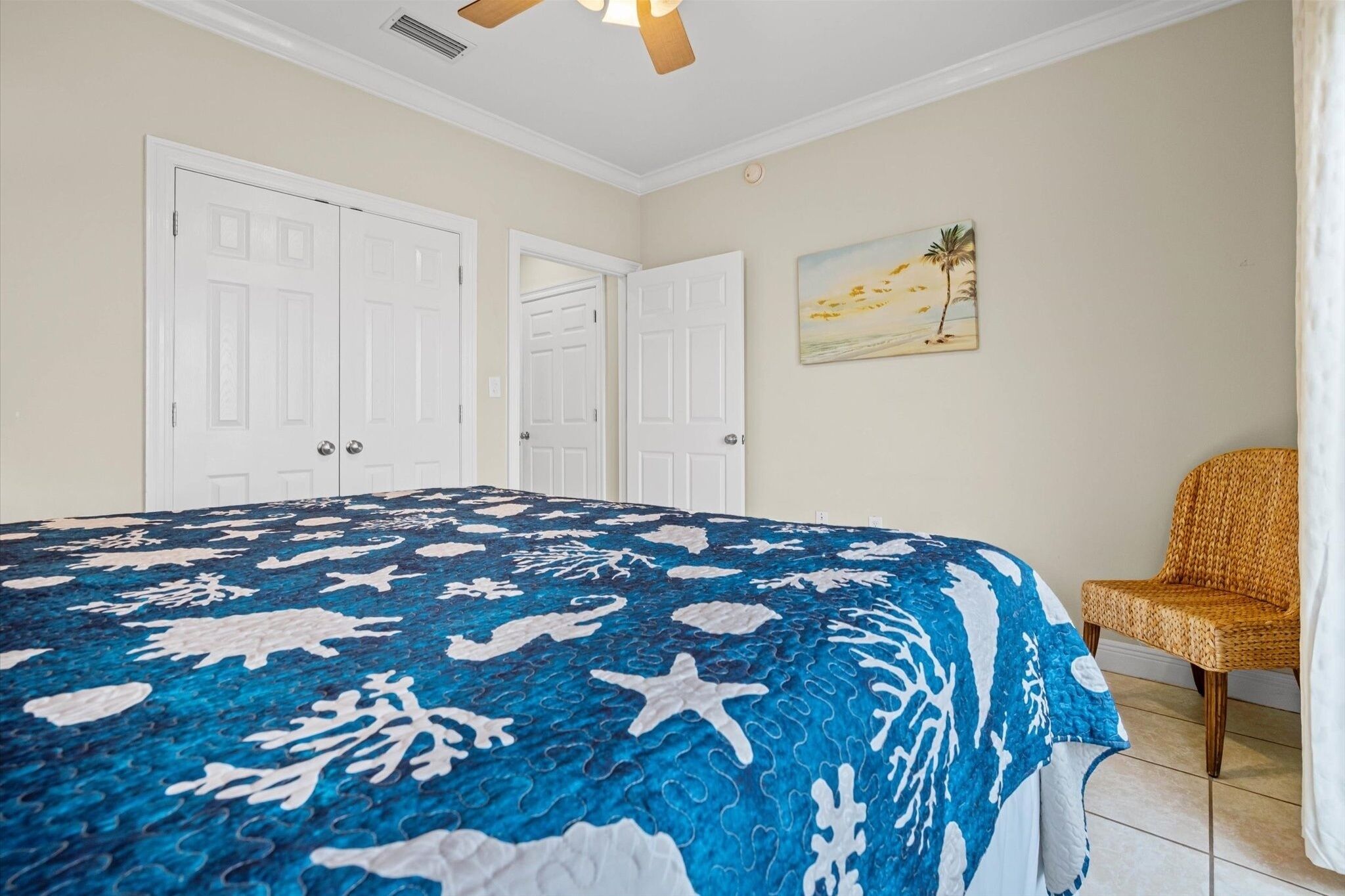 A bedroom with a bed, a chair, and a painting on the wall.