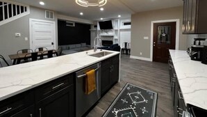 A modern kitchen with a central island, built-in appliances, and a dining area with a table and chairs. - Minutes from Anything Downtown Indy! (Indianapolis)