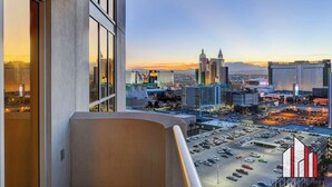 A cityscape view from a high-rise building with a parking lot below. - MGM Signature-  Studio F1 Track Strip View Balcony (Las Vegas)