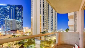 A high-rise building with a glass balcony overlooking a landscaped area with a pool. - Luxury Studio | Jacuzzi, Balcony & Full Bath (Las Vegas)