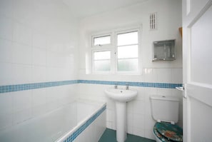 Bathroom features a pedestal sink, toilet, and bathtub.
