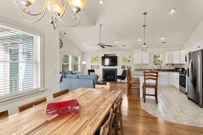 A spacious kitchen with white cabinets, a large island, and a stainless steel refrigerator. - Boromacha: Private Pool, Hot Tub, Club Access (Corolla)