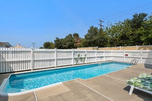 A rectangular swimming pool with a white fence, a concrete deck, and lounge chairs. - Boromacha: Private Pool, Hot Tub, Club Access (Corolla)