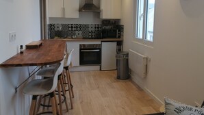 Una cocina moderna con armarios blancos, una isla de madera y un salpicadero con diseño.