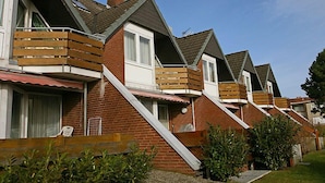 Una hilera de casas modernas con fachada de ladrillo y balcones de madera.