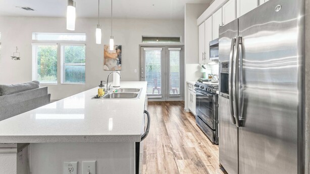 A modern kitchen with a central island, stainless steel appliances, and pendant lighting. - Cozy 2BR suite close to Downtown w/ fast WiFi (Austin)