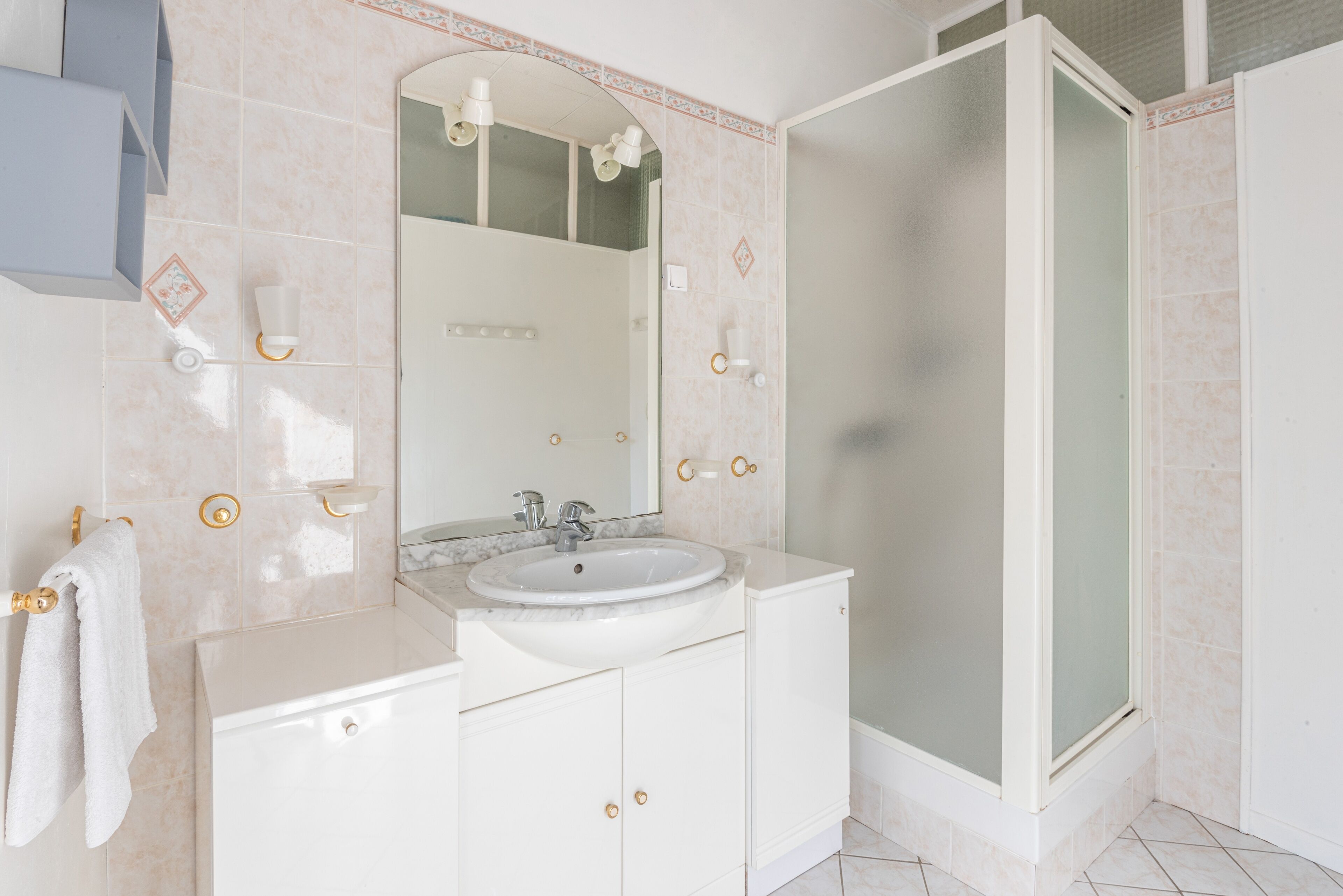 Une salle de bain équipée d’un lavabo, d’un miroir, d’un meuble-lavabo et d’une douche.