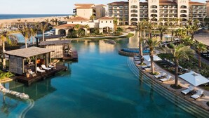 A resort with a central pool, lounge areas, and a beachfront view. - Stunning Greg Norman Golfers Paradise with Golf Access (Cabo San Lucas)