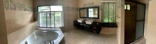 A bathroom with a bathtub, two sinks, a large mirror, and a shower area. - Stunning Oceanfront 4-Bdrm Villa w/ Infinity Pool (Playa Hermosa)