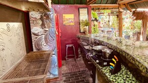 A kitchen with a checkered tile backsplash, a stove, and a sink.