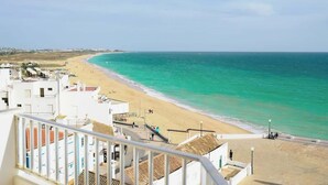 Vista costera con playa, edificios y cielo despejado.