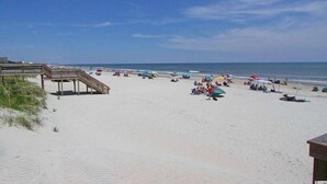 A beach with a wooden boardwalk, beach umbrellas, and people relaxing on the sand. - BEACH BLISS 2Bedroom/2 Bath condo in Litchfield! (Pawleys Island)