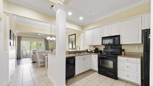 A modern kitchen with white cabinets, a black stove, and a microwave. - BEACH BLISS 2Bedroom/2 Bath condo in Litchfield! (Pawleys Island)