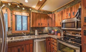 A kitchen with wooden cabinets, a stainless steel refrigerator, a microwave, and a dishwasher.