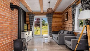Interior acogedor de una cabaña con chimenea, sofá y paredes de madera.