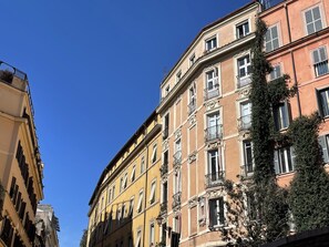 Un edificio de varios pisos con balcones y un cielo azul despejado.