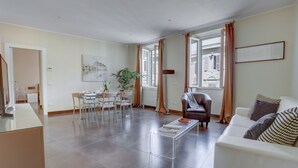 A spacious living area with a dining table, chairs, a sofa, and a coffee table. - Colosseo Gardens - C8 (Rome)
