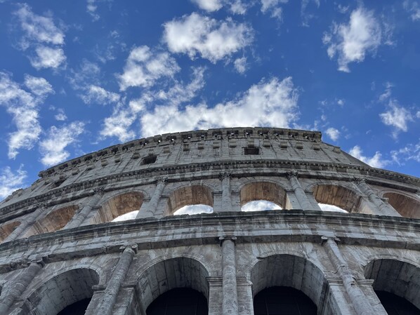 The Colosseum with its arches and columns, under a clear sky. - Monti Apartments - M14 (Rome)