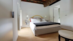 A bedroom with a bed, bedside tables, a chair, and a wardrobe. - Il mulino di Trastevere - G2 (Rome)