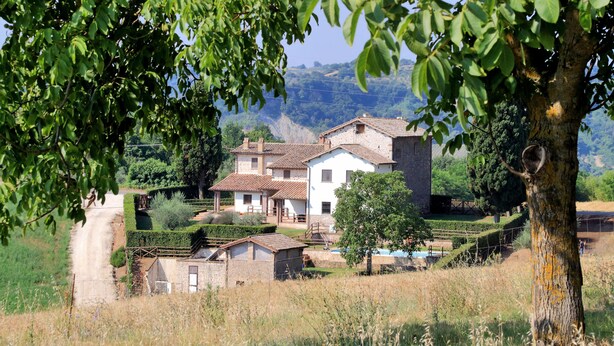 Una casa rural con jardín, una piscina pequeña y vistas al campo.