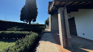 Un sendero que conduce a un edificio con techo de tejas y paredes de piedra.
