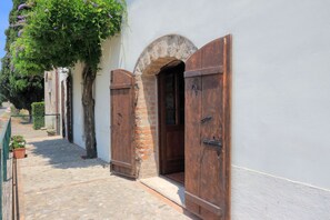 A narrow cobblestone pathway leading to a rustic building with wooden shutters and a stone archway. - Trianon Country - C - Two Bedroom Apartment, Sleeps 6 (Orvieto)
