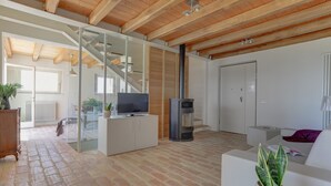 Un salon moderne doté d’une cheminée, d’un téléviseur et d’un escalier menant à un autre niveau.