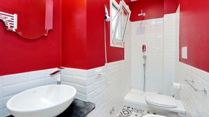 Une salle de bain avec un lavabo blanc, des toilettes et une douche.
