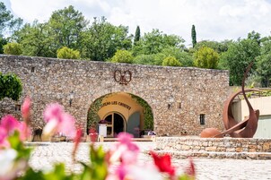 A stone building with an arched entrance labeled "CHATEAU LES CROSTES."