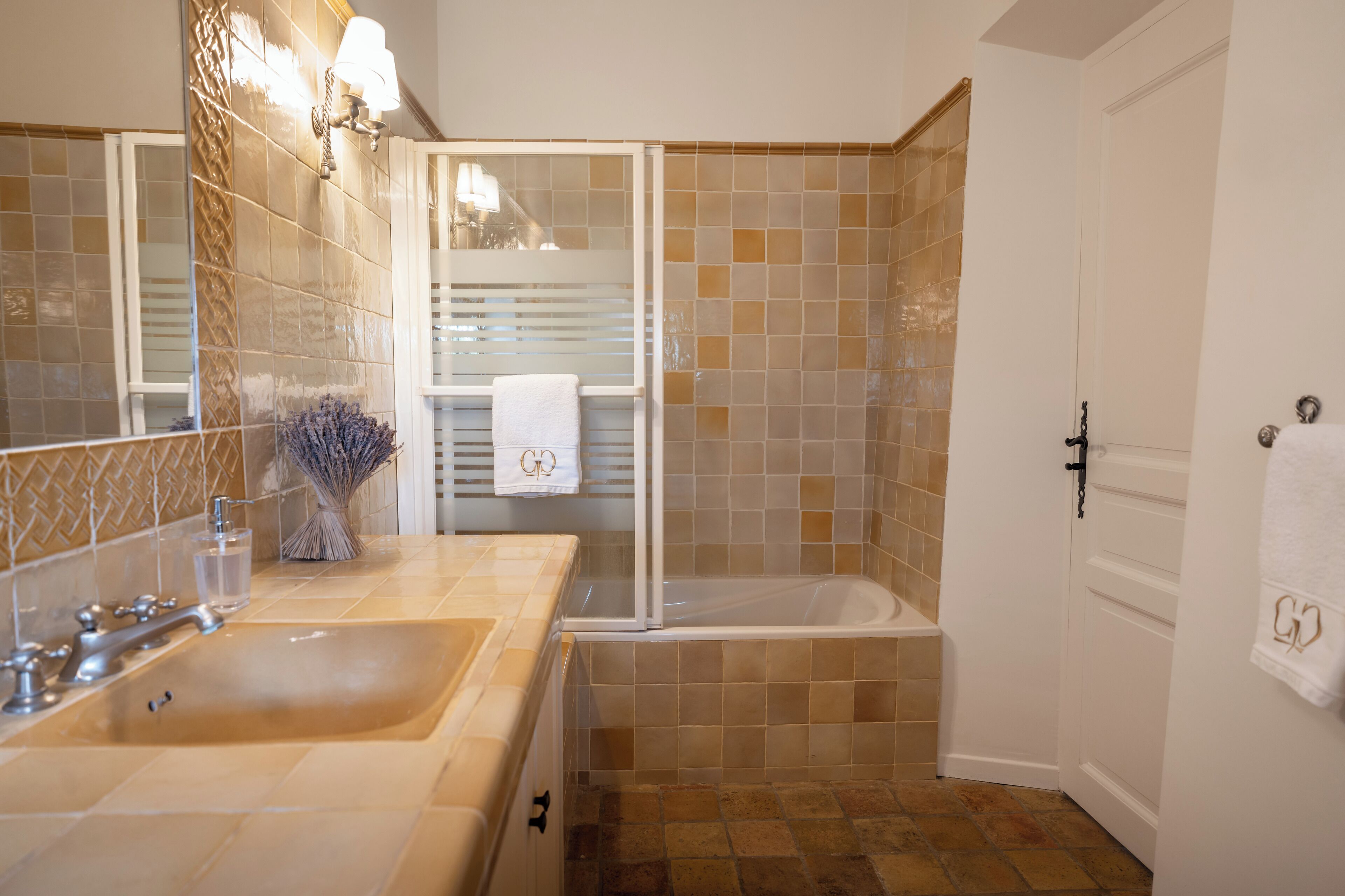 A bathroom with a sink, mirror, and bathtub.