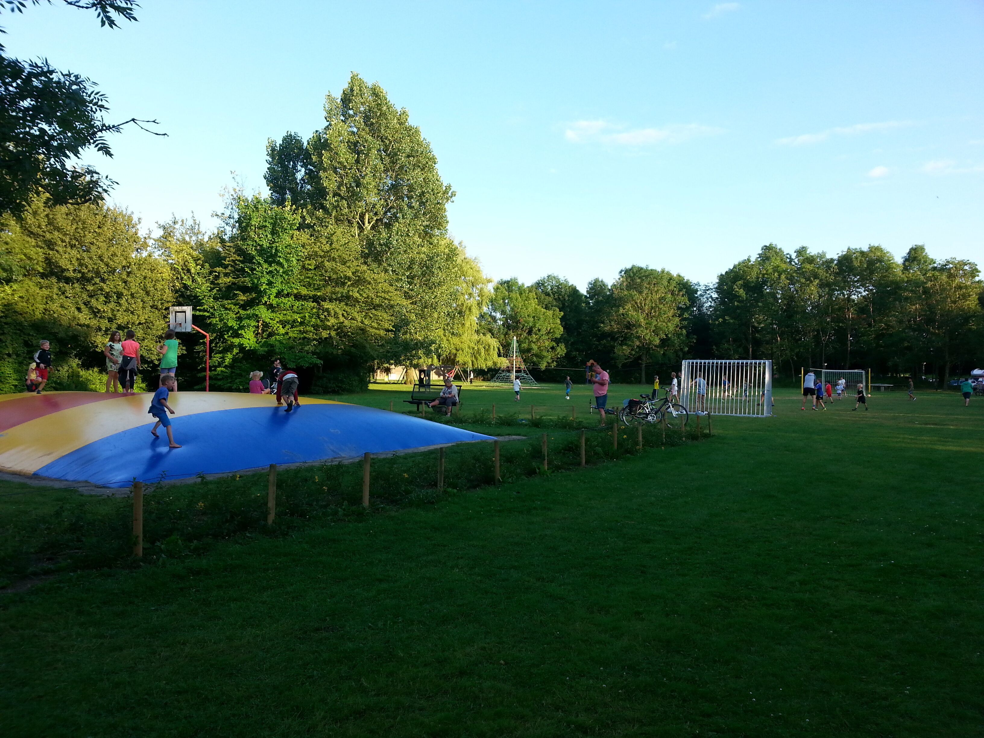 Ein Spielplatz mit Basketballkorb, Fußballtor und einem blauen Spielbereich.