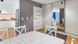 Een moderne keuken met witte kasten, een roestvrijstalen koelkast en een houten aanrecht.