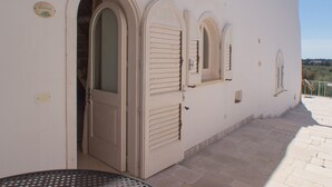 Un edificio con puertas y ventanas de arco, un patio con baldosas y un letrero que dice "Salma".
