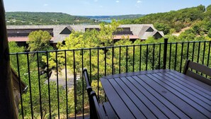 Ein Balkon mit Blick auf eine bewaldete Landschaft und ein weiter See.