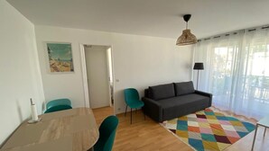 Una sala de estar con un sofá, una mesita de centro y un tapete colorido.