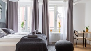 A modern bedroom with a bed, bedside tables, a desk, and a chair. - Limehome Essen Kettwiger Str. (Essen)