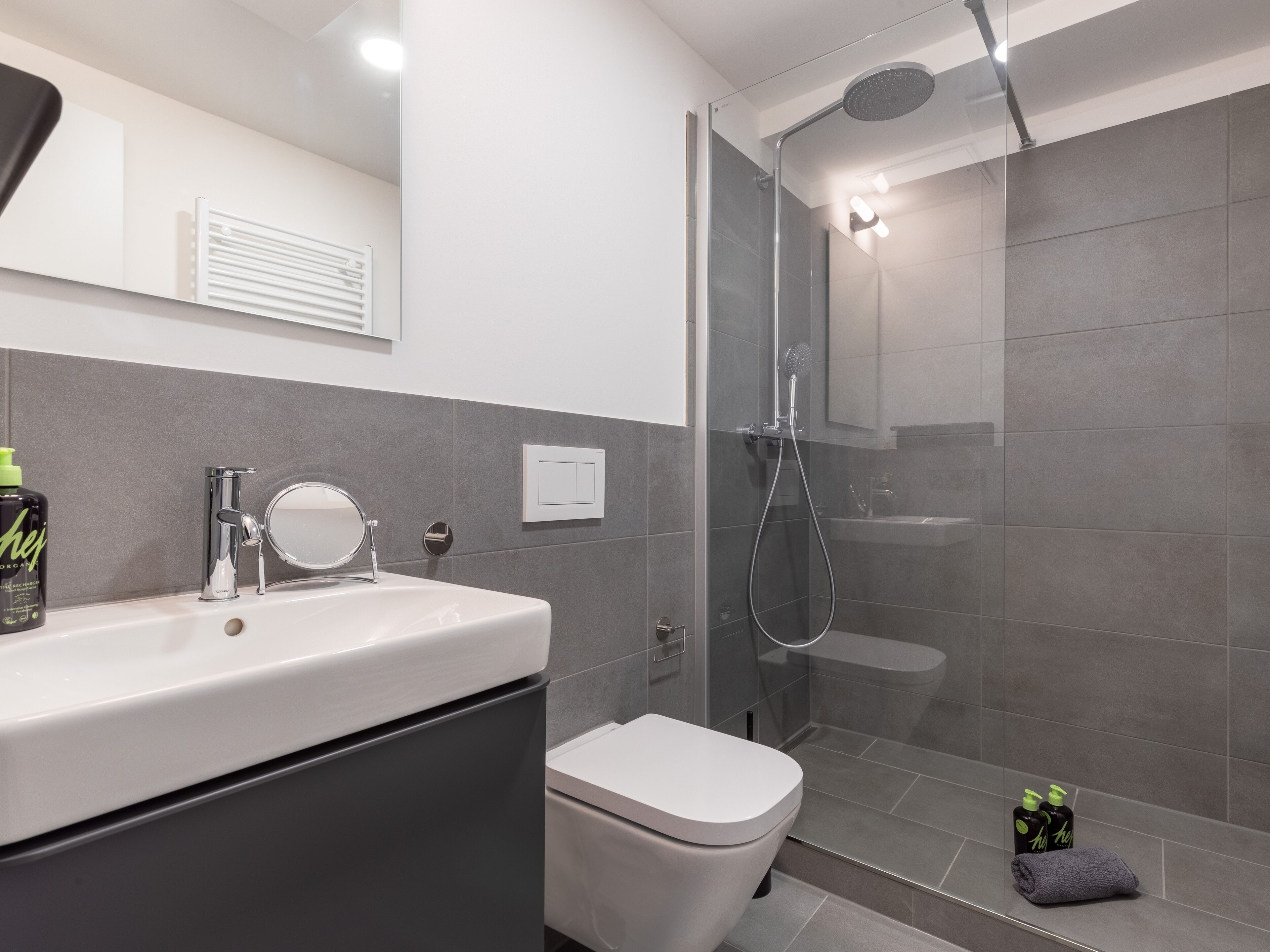 A modern bathroom with a shower, toilet, and sink.