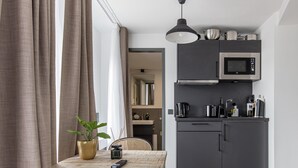 A compact kitchen with a microwave, coffee maker, and cabinets. - Limehome Essen Kettwiger Str. (Essen)
