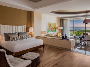 Ruime hotelkamer met een groot bed, een zithoek en uitzicht op de omgeving.