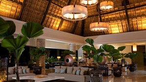 A spacious lobby with a high ceiling, large potted plants, and a modern sofa arrangement. - 5 star resort week of mexico open held at same resort (Nayarit CP)