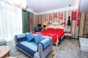 Una habitación de hotel con una cama, un sofá, un escritorio y una silla.