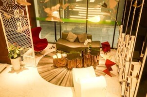 A modern interior with a circular seating area, a red chair, and a glass partition.