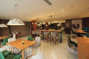 A modern restaurant interior with a bar area, seating arrangements, and pendant lighting. - Ceeci Hotel (Xichuan)