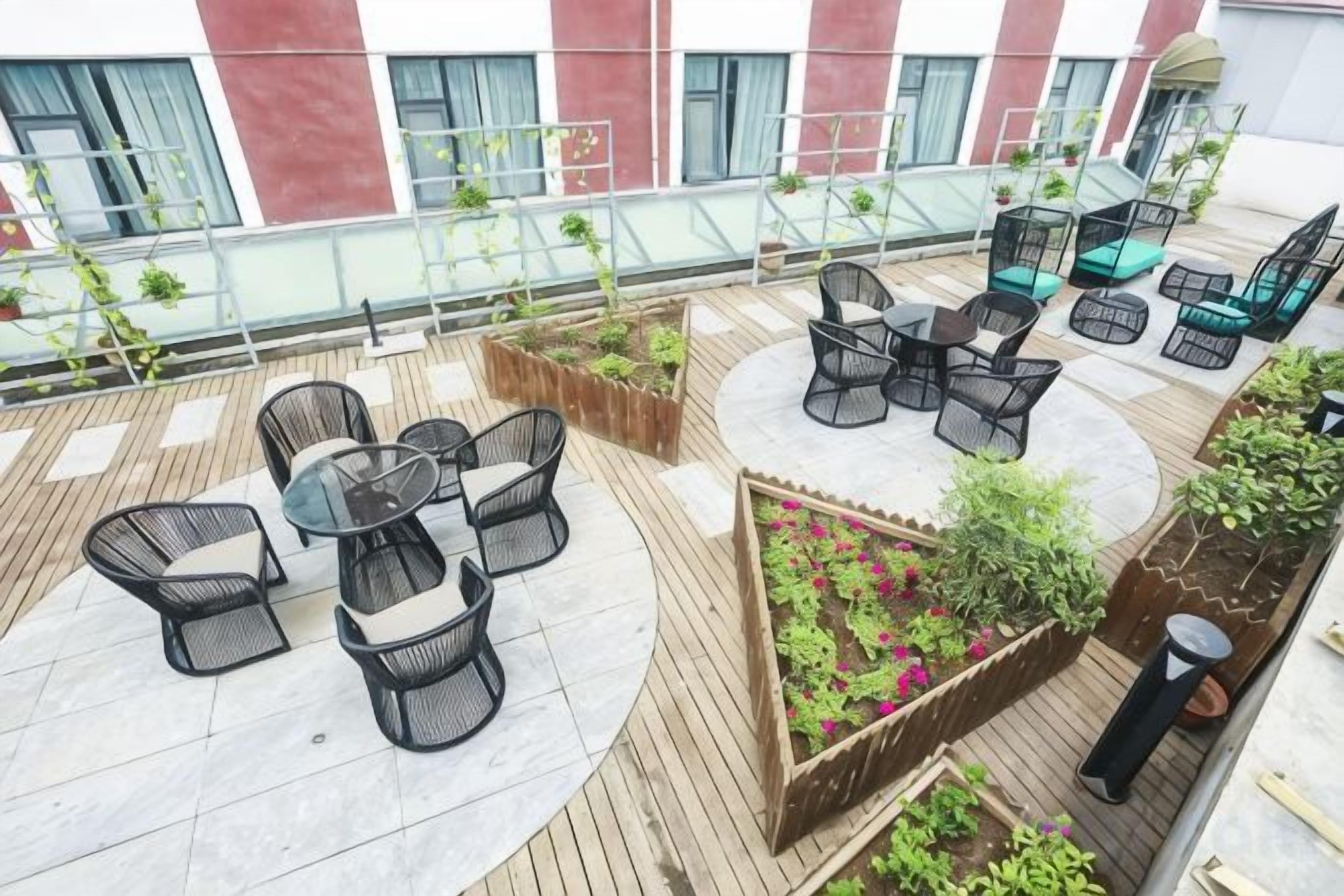 Una terrazza sul tetto con posti a sedere all'aperto, fioriere e vista sulla facciata dell'edificio.