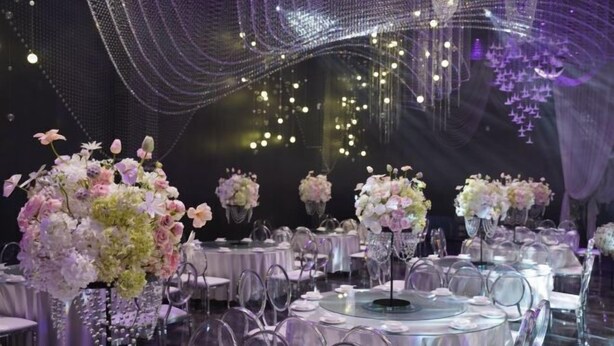 A formal dining area with round tables, clear chairs, and floral centerpieces. - Ceeci Hotel (Xichuan)