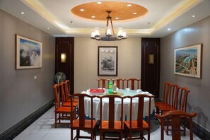 A dining room with a round table, chairs, and a chandelier. - Ceeci Hotel (Xichuan)